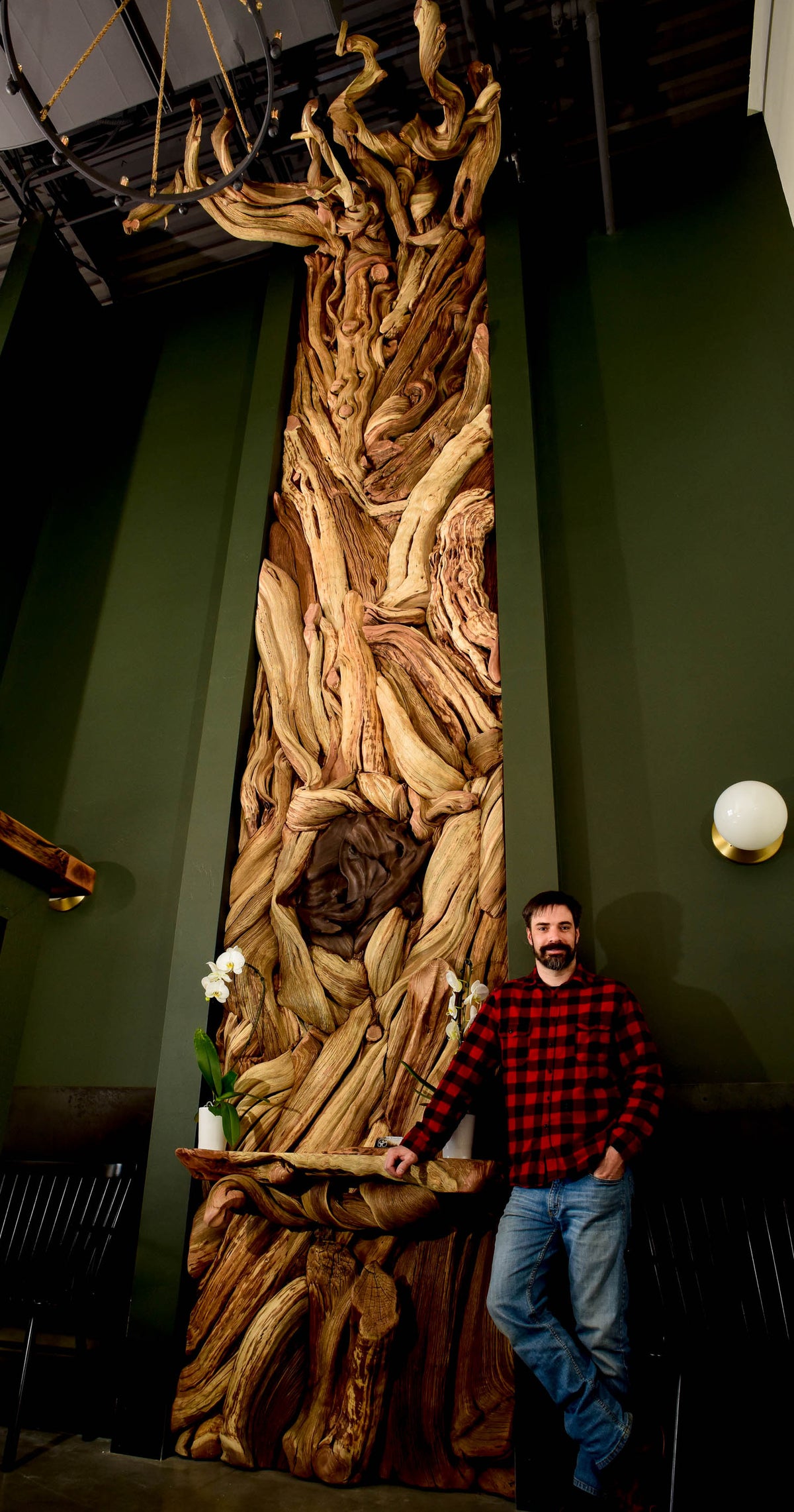 artist Tom Benedict stands by his work, the taglewood wall, in Bozeman, Montana